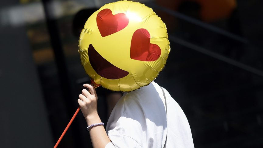 A woman holds a balloon as she walks past a store on Valentine's Day