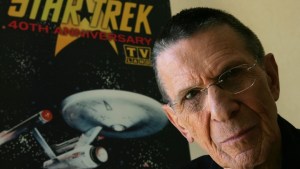 Leonard Nimoy poses in front of a vintage Star Trek poster