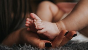 A mother holds her newborn's feet