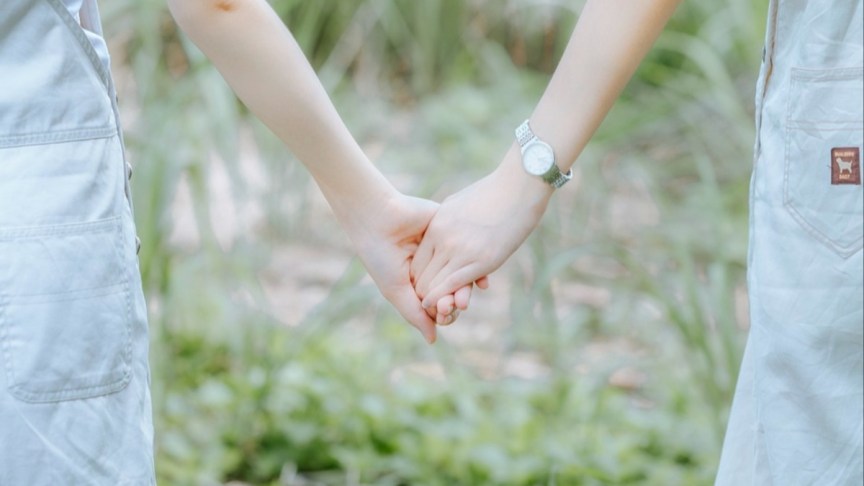 Women holding hands.
