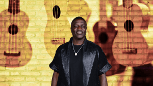 Akon posing in front of a wall of guitars