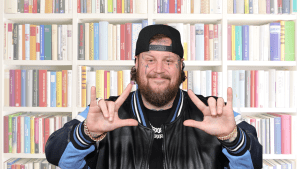 Jelly Roll smiling in front of books
