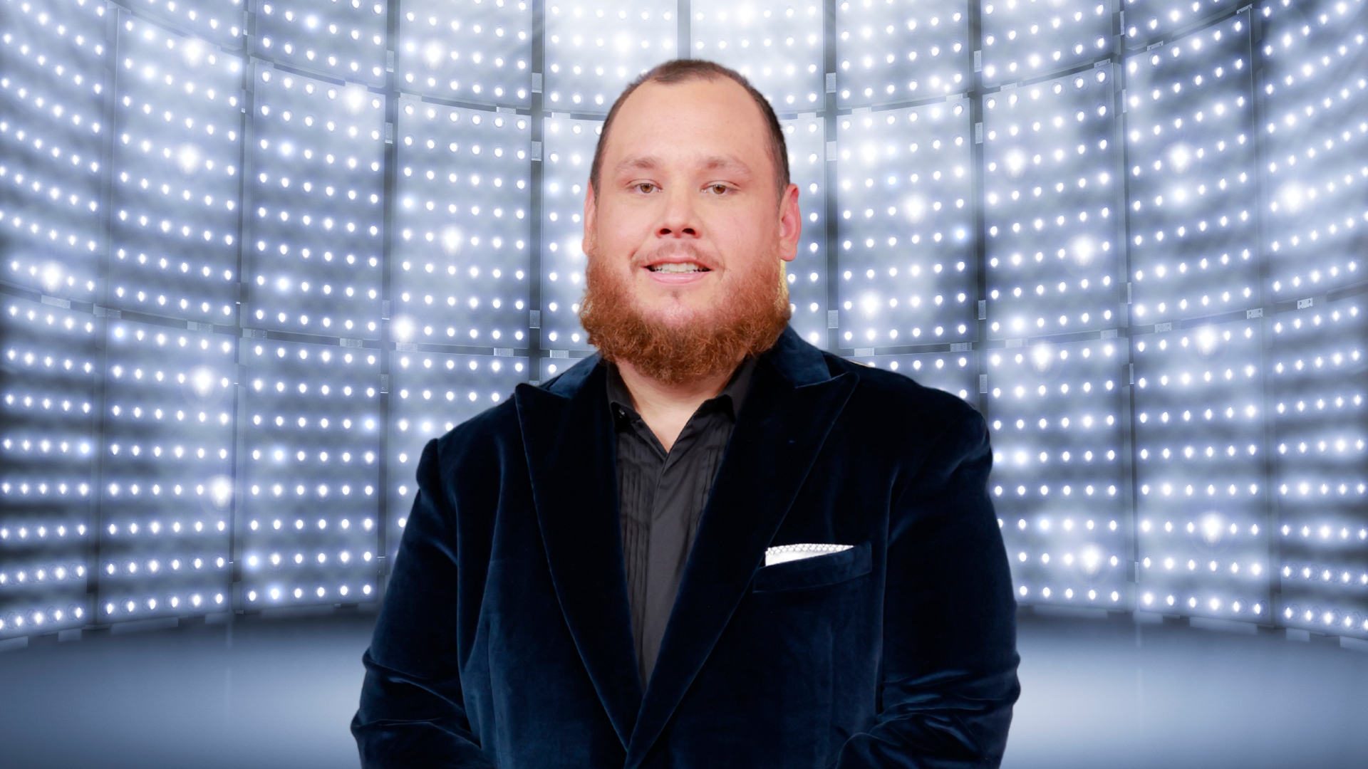 Luke Combs smiling in front of a bright background
