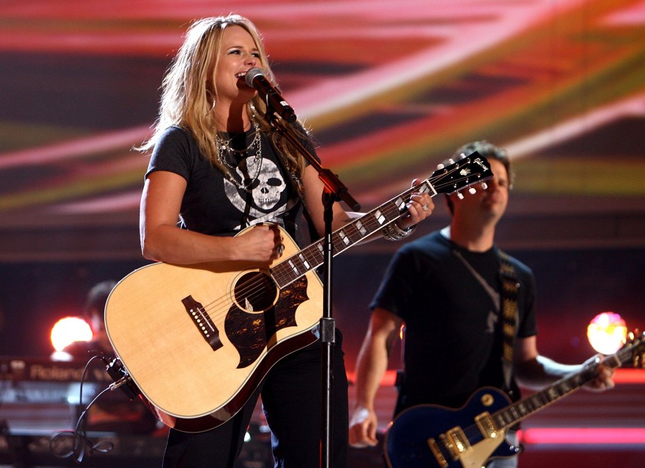 Miranda Lambert playing guitar and singing into a microphone