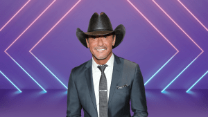 Tim McGraw smiling on a colorful stage