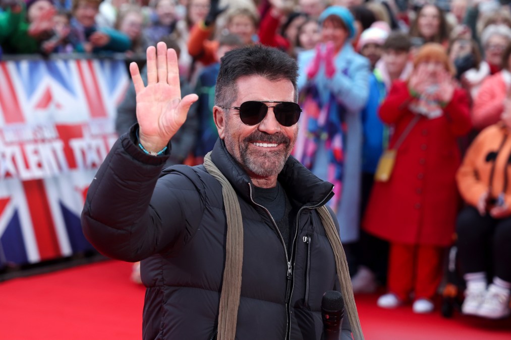 Simon Cowell smiling and waving