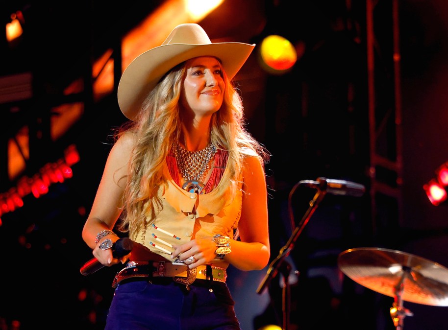 Lainey Wilson smiling on stage.