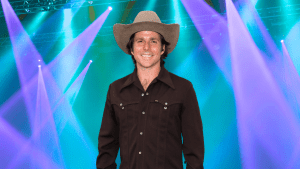 Lukas Nelson posing in front of colorful lights