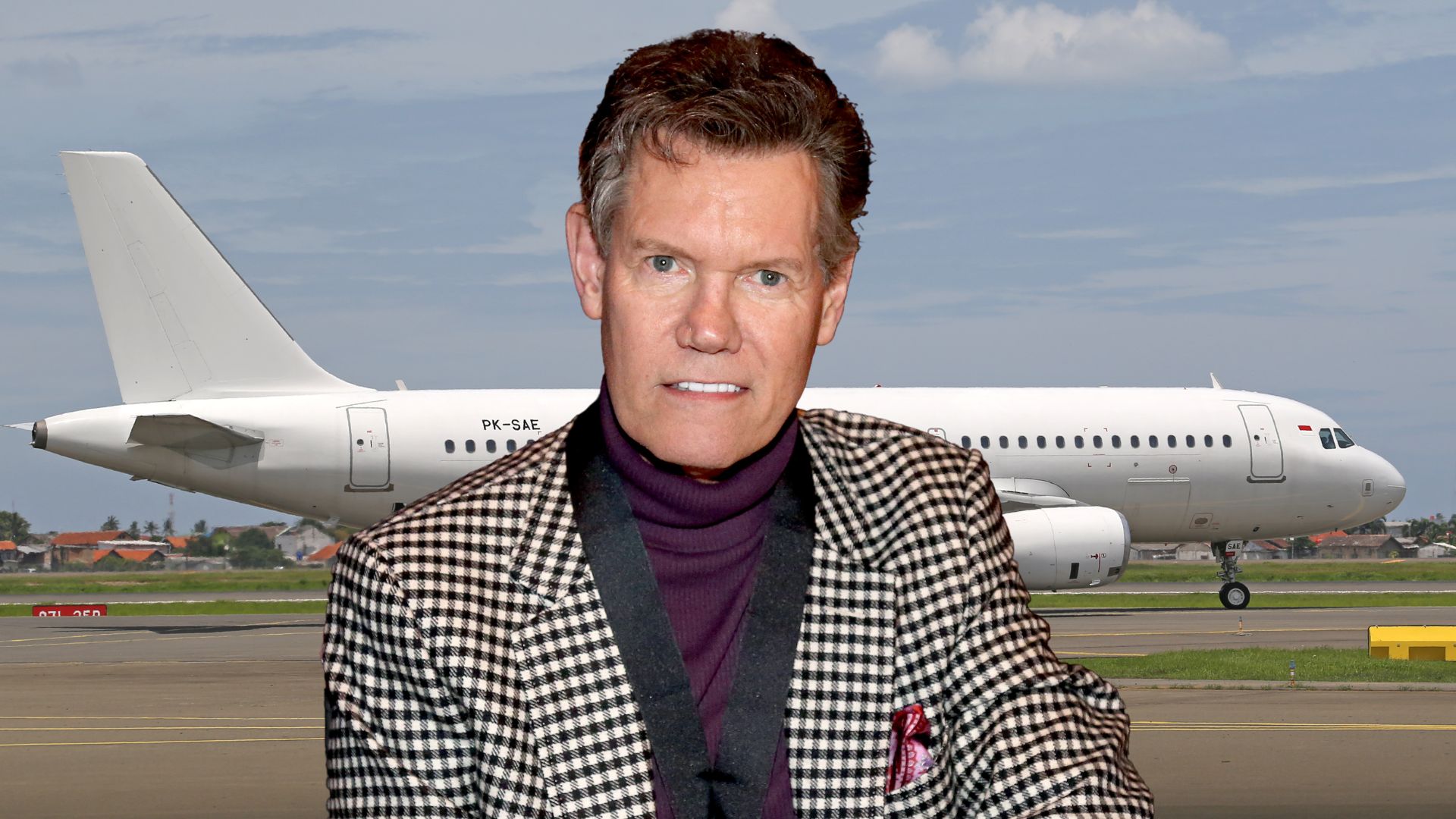 Randy Travis smiling on a tarmac