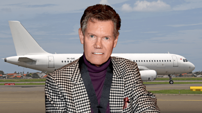 Randy Travis smiling on a tarmac