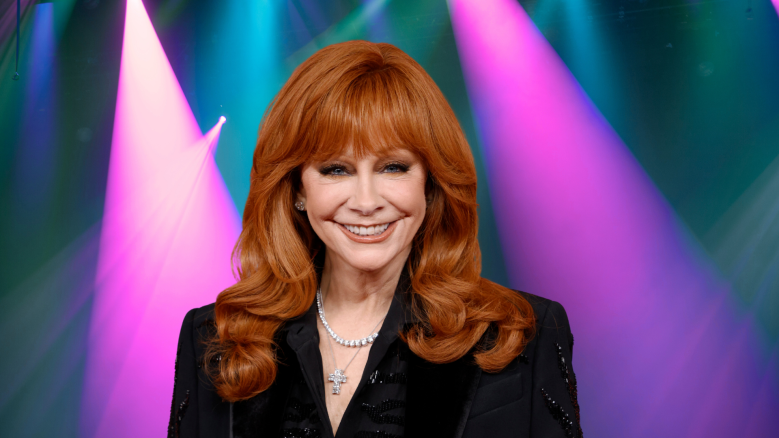Reba McEntire smiling in a black jacket.