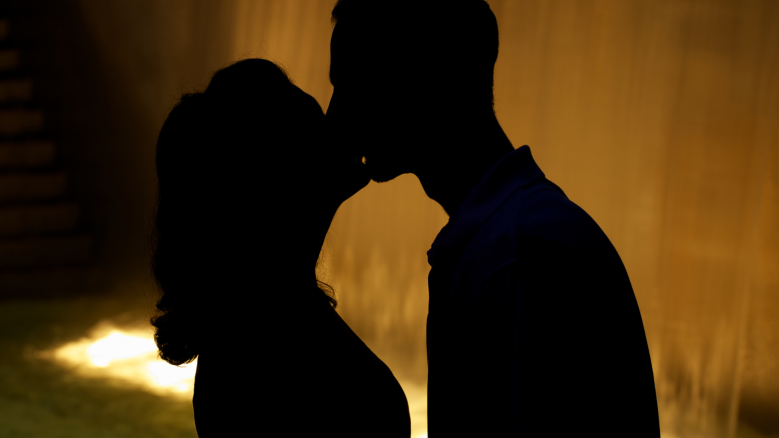 A man and woman kissing in silhouette