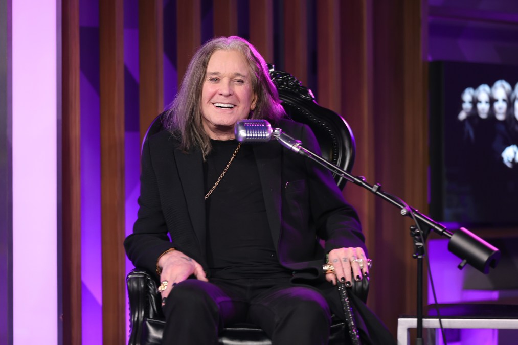 Ozzy Osbourne smiling behind a microphone.