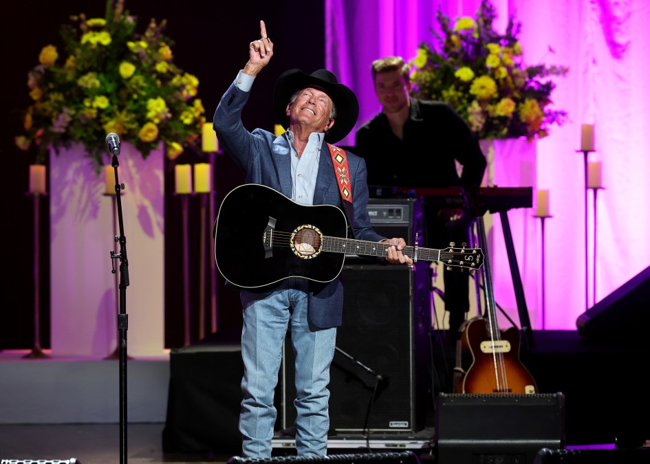 George Strait pointing to the sky on stage