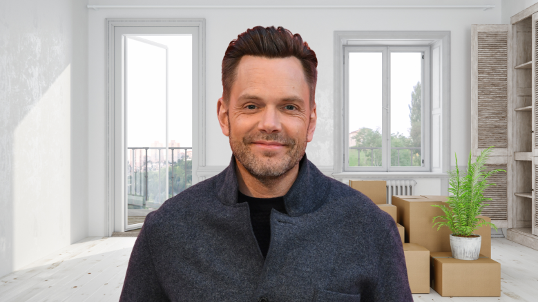 Joel McHale smiling in a house.