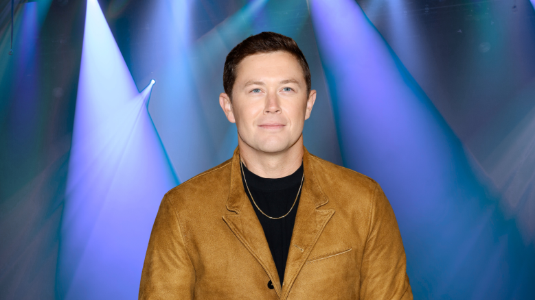 Scotty McCreery posing under blue lights