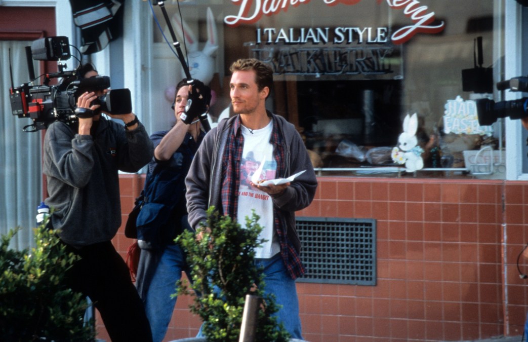 Matthew McConaughey holding pizza slice in front of the camera