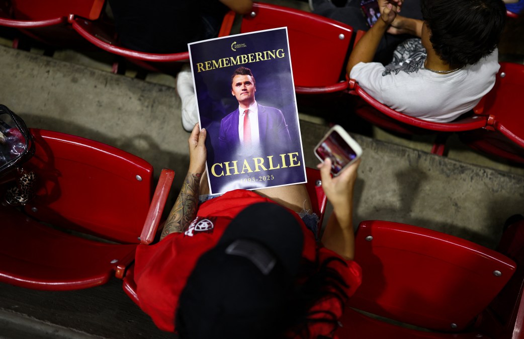 An attendee holds a flyer during a vigil in memory of activist Charlie Kirk 