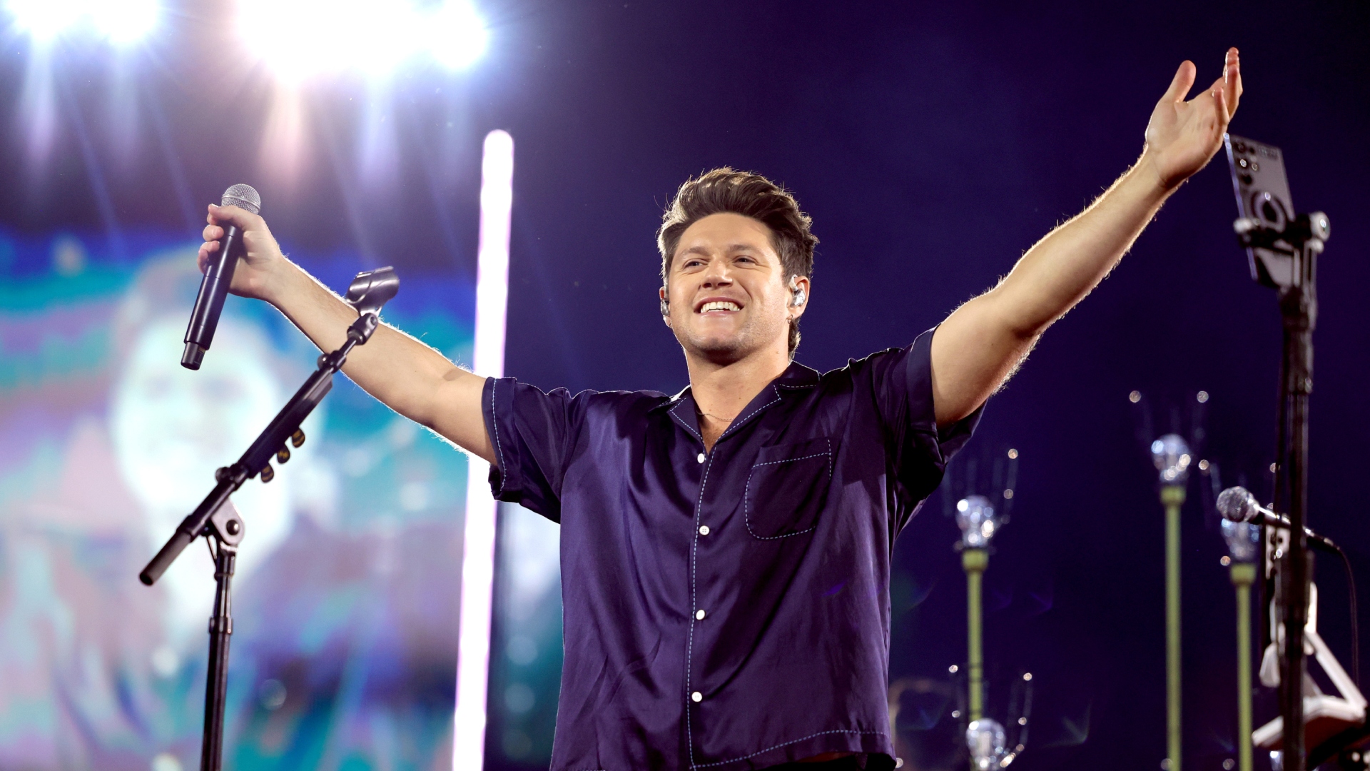 Niall Horan performing onstage, smiling