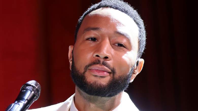 John Legend performing behind a piano at an event