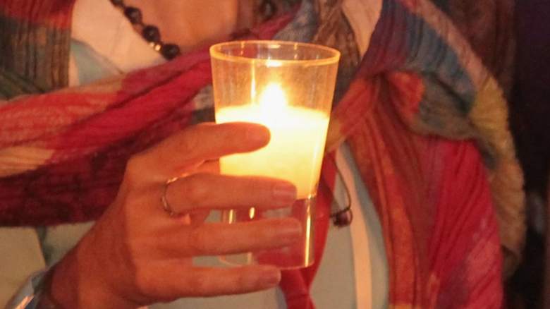 woman holding burning candle