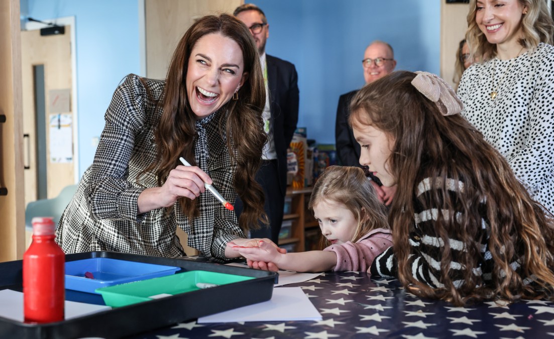 Catherine, Princess of Wales paints the hand of Maggie aged 4 years old whose sibling is being treated at TA Hafan