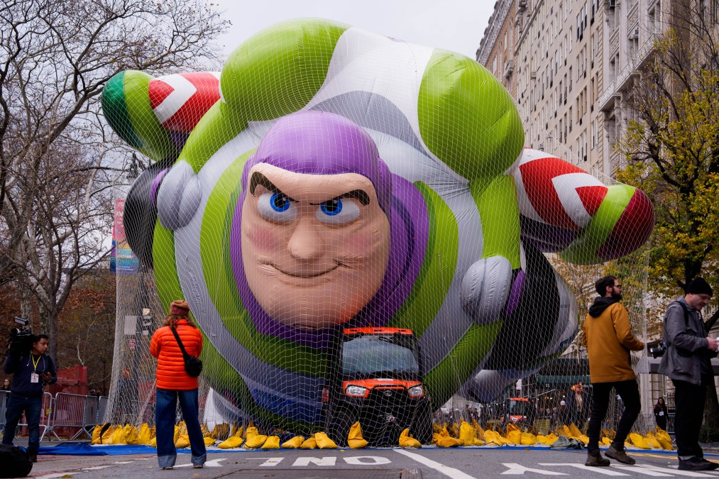 People walk near the new Buzz Lightyear balloon during Macy's Balloon Inflation 2025
