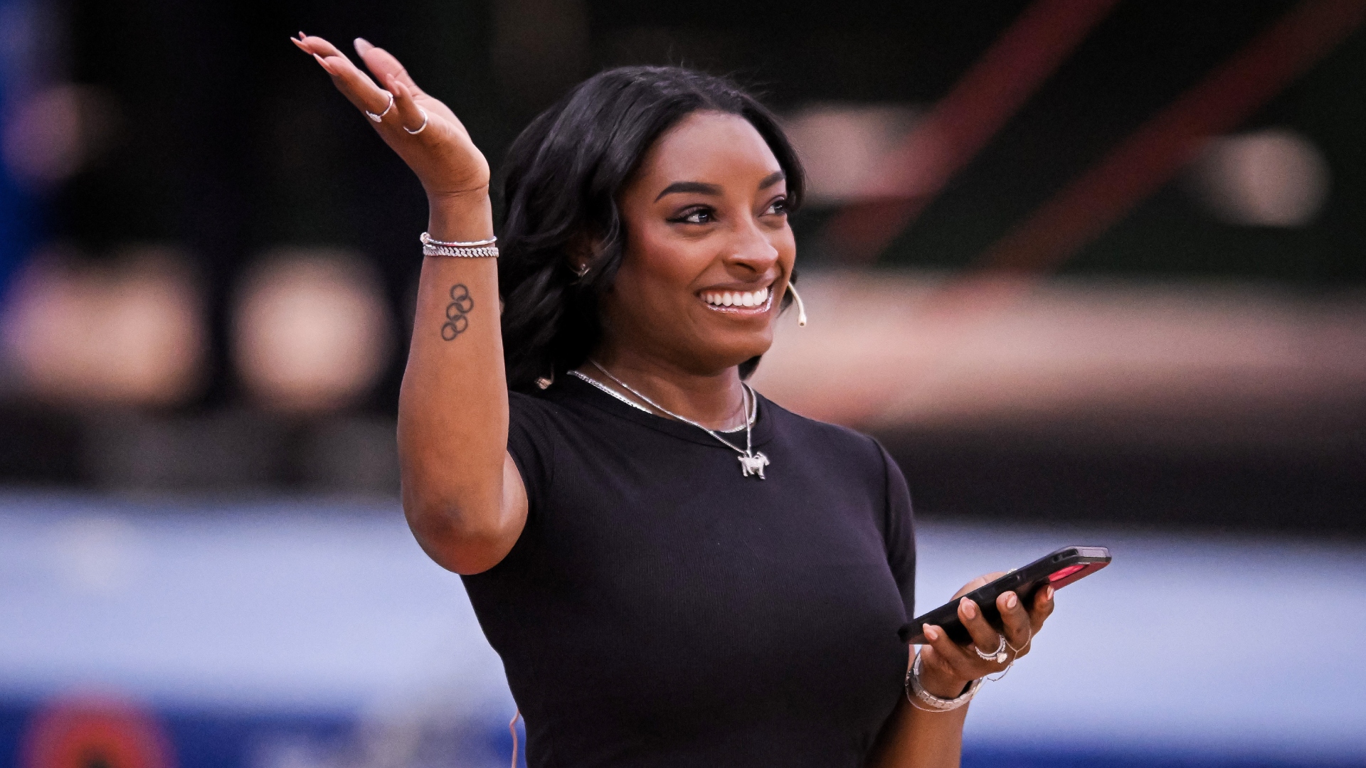 Simone Biles smiling and waving