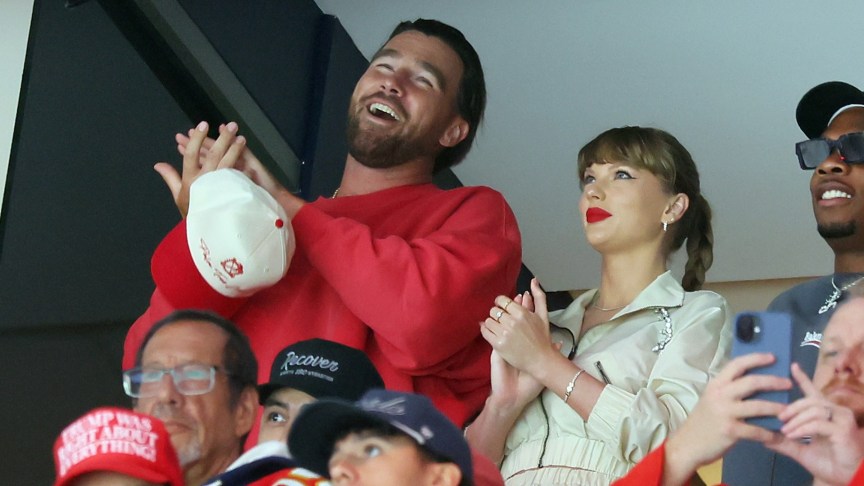 Taylor Swift and Travis Kelce smiling and clapping
