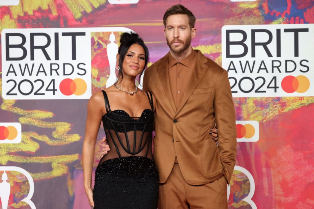Vick Hope and Calvin Harris pose on the red carpet upon arrival for the BRIT Awards 2024