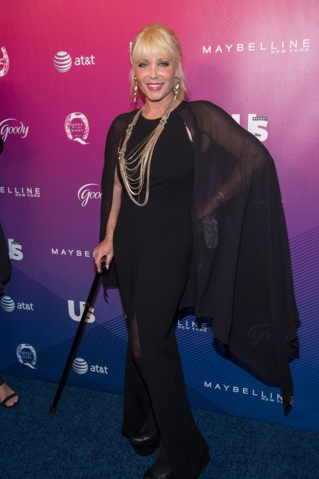 Pamela Bach smiling and walking with a cane