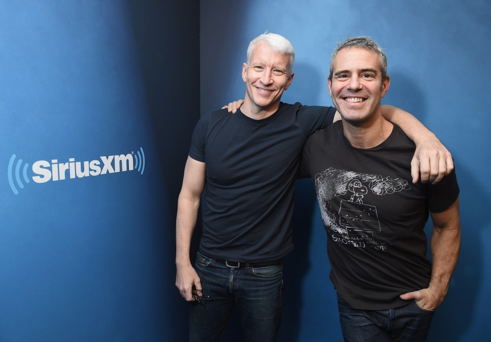 Anderson Cooper and Andy Cohen embracing and smiling