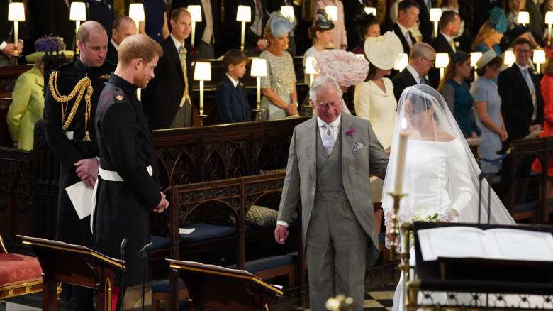 Prince Harry looks at his bride, Meghan Markle, as she arrives accompanied by Prince Charles, Prince of Wales during their wedding in St George's Chapel at Windsor Castle on May 19, 2018 in Windsor, England