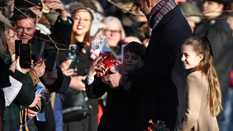 Britain's Prince Louis of Wales reacts with his father Britain's Prince William, Prince of Wales and sister Britain's Princess Charlotte of Wales as he receives a giant chocolate from a well-wisher upon leaving after attending the Royal Family's traditional Christmas Day service at St Mary Magdalene Church on the Sandringham Estate in eastern England, on December 25, 2025