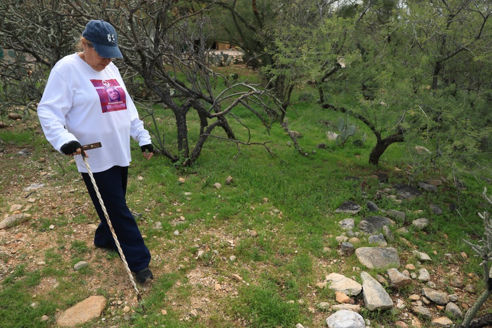 Lidia Hernandez, who is part of the Madres Buscadoras De Sonora (Searching Mothers of Sonora), searches the area around Nancy Guthrie's residence
