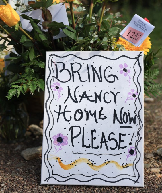 A sign sits in a memorial near Nancy Guthrie's residence