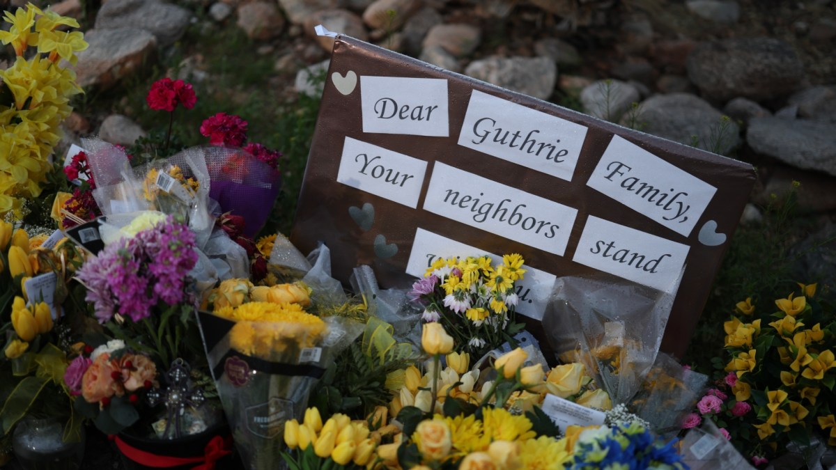Flowers and a poster showing support for Nancy Guthrie