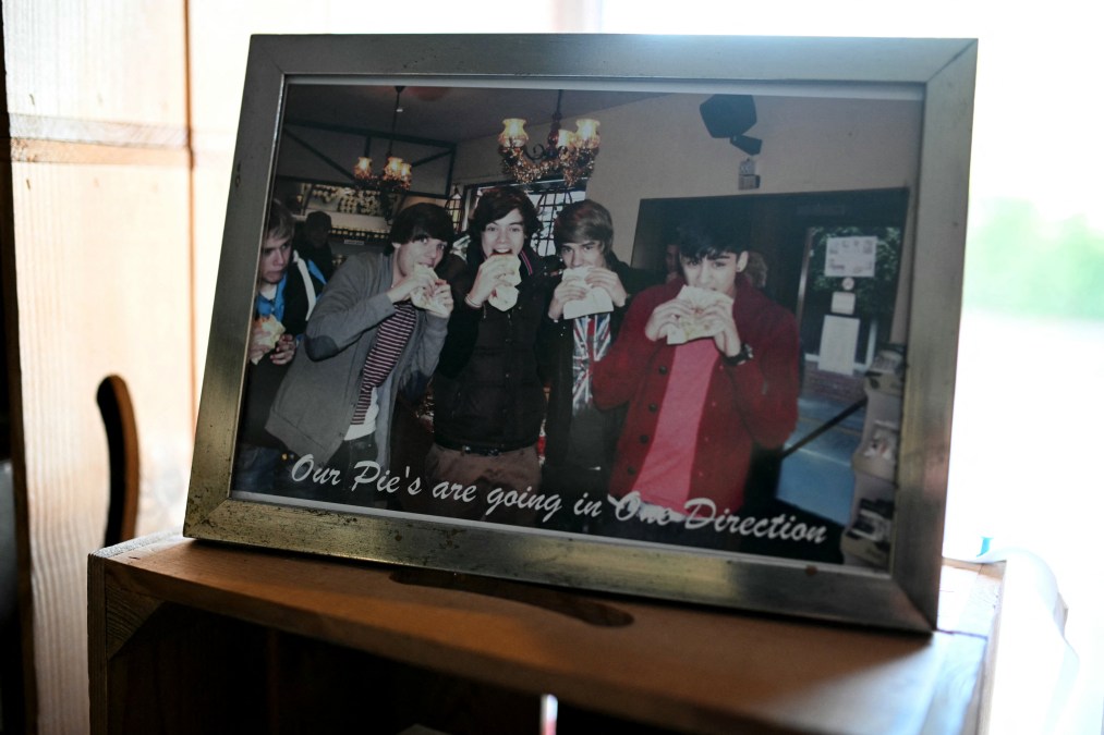 A photo of Harry Styles and his One Direction band mates, Nial Horan (L), Louis Tomlinson (2L), Liam Payne (2R) and Zain Malik is pictured inside the W Mandeville bakery in Holmes Chapel, north west England, on March 4, 2026, where Styles used to work.