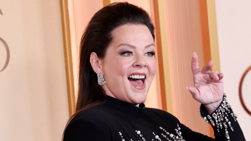 Melissa McCarthy looked absolutely stunning at the 2026 Oscars, and her outfit choice was a real showstopper. The actress walked the red carpet with her husband, Ben Falcone, and she opted for a striking, figure-hugging gown that showed off her curves. Melissa McCarthy Wows on the Red Carpet The dress features long sleeves and a high-neckline, a style that is simple and elegant. However, the beading detail added a wow-factor. To complete her look, McCarthy swept her hair back, kept her makeup natural, and wore a pair of dangling diamond earrings. She carried a black clutch that matched her outfit. Melissa McCarthy waves on the Oscars red carpet