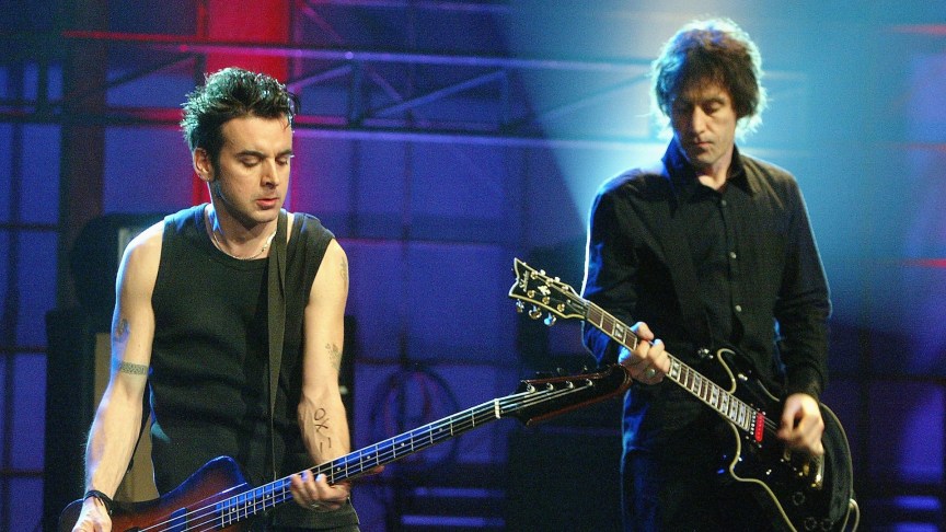 Rock band The Cure bassist Simon Gallop and guitarist Perry Bamonte perform onstage