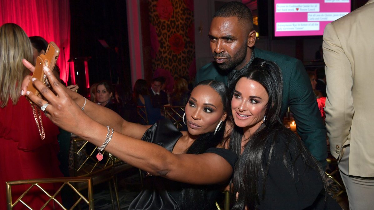 Cynthia Bailey, Justin Sylvester, and Kyle Richards pose for a selfie at a Beverly Hills event