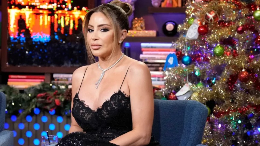 Larsa Pippen sits on the “Watch What Happens Live” set wearing a black dress during an appearance with Andy Cohen