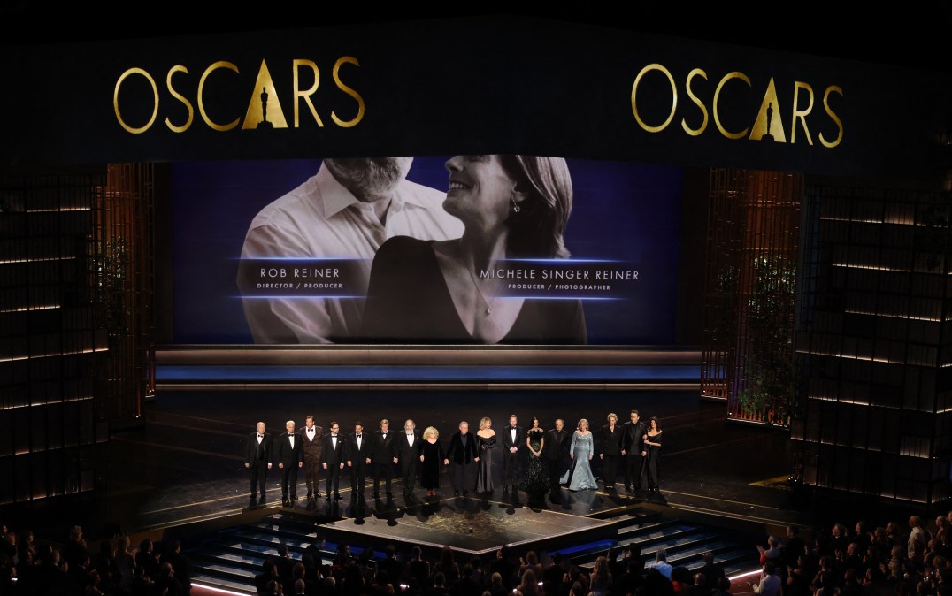 Michael McKean, Christopher Guest, Jerry O'Connell, Wil Wheaton, Fred Savage, Cary Elwes, Mandy Patinkin, Carol Kane, Billy Crystal, Meg Ryan, Kiefer Sutherland, Demi Moore, Kevin Pollak, Kathy Bates, Annette Bening, John Cusack and Daphne Zuniga stand onstage in front of a screen showing a photo of late US director Rob Reiner and his wife late US photographer Michele Reiner during the 98th Annual Academy Awards