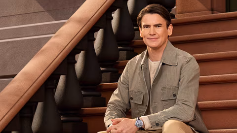 Nick Barber sits on brownstone steps in “In the City” Season 1 promo photo