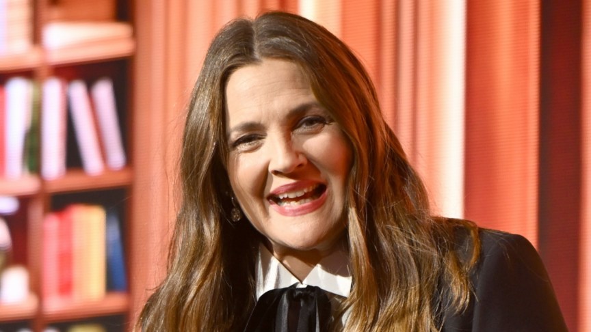 Drew Barrymore smiling onstage at an event