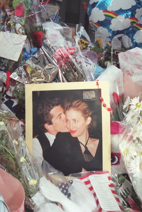 A photo of John F. Kennedy Jr and his wife Carolyn Bessette Kennedy is surrounded by balloons and flowers at a makeshift shrine in front of their apartment building in New York City 21 July 1999. The body of John F. Kennedy, Jr has been located and removed from the wreckage of the small plane he was flying with his wife Carolyn Bessette Kennedy and her sister Lauren G. Bessette on 16 July off the coast of Martha's Vineyard. 