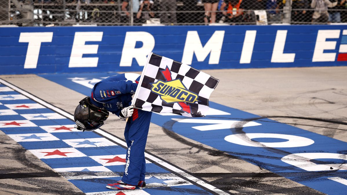 Kyle Busch bows with the checkered flag after winning the NASCAR Craftsman Truck Series ECOSAVE 200 at Dover Motor Speedway in May 2026.