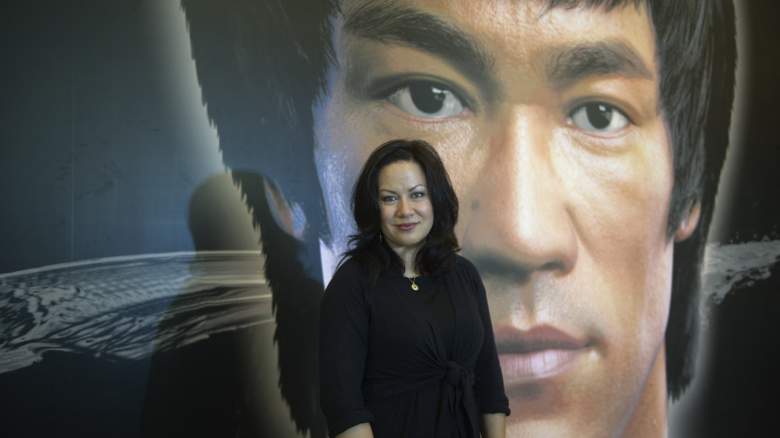 Shannon Lee stands infront of photo of Bruce Lee