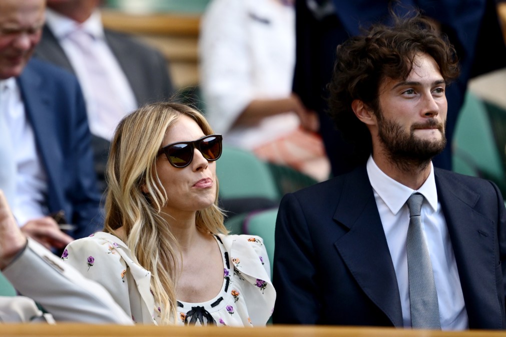 Actor Sienna Miller and Oli Green smile in the Royal Box during the Ladies' Singles quarter-final match between Aryna Sabalenka and Laura Siegemund