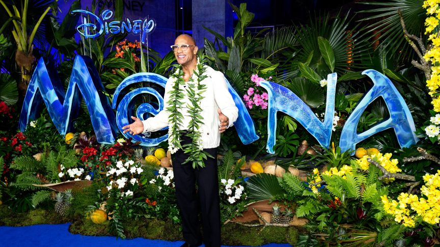 Dwayne Johnson in front of the "Moana" logo.